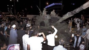 People stop a tank at Ataturk airport in Istanbul, early Saturday, July 16, 2016. Members of Turkey's armed forces said they had taken control of the country, but Turkish officials said the coup attempt had been repelled early Saturday morning in a night of violence, according to state-run media. (Ismail Coskun/IHA via AP)